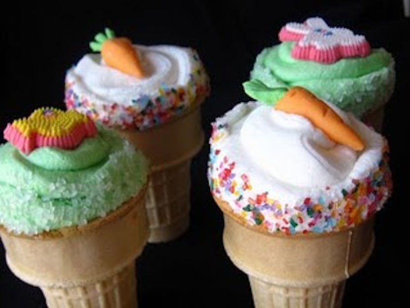 Four ice cream cone cupcakes decorated with colorful sprinkles and an Easter garnish