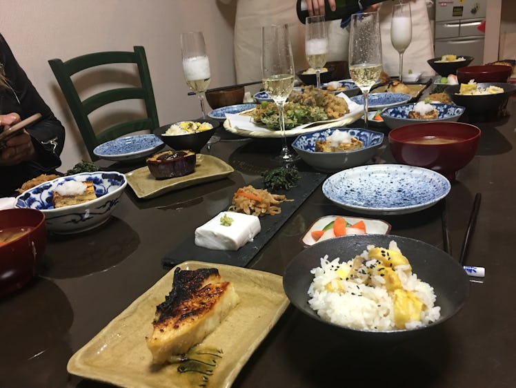 A table is filled with plates of food and flutes of champagne in Kyoto, Japan.