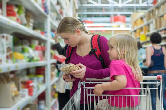 Mother and daughter shopping in cookies section in supermarket