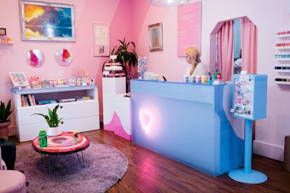 The interior of Cute Nail Studio in Austin, Texas features pink walls and colorful decor.