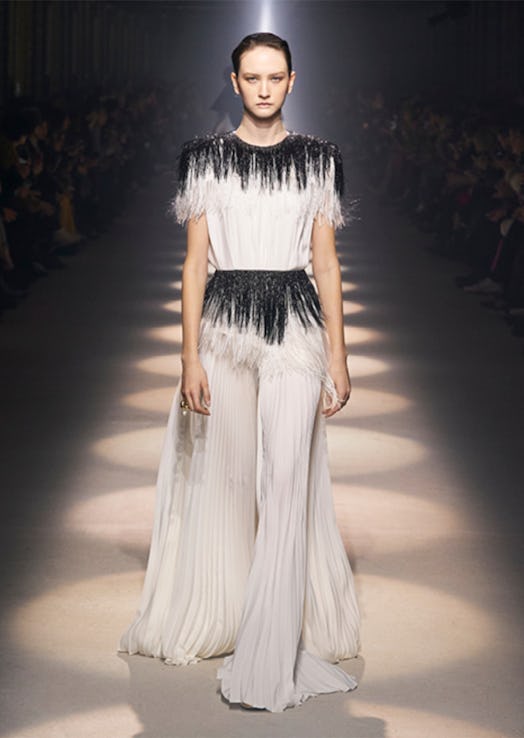 A model walking the runway in a black-and-white maxi evening dress by Givenchy