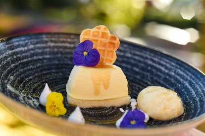 Purple and yellow flowers decorate a honey-mascarpone cheesecake, which is served at the 2020 Epcot ...
