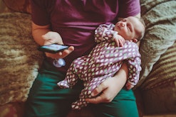 A parent holds a newborn on their lap