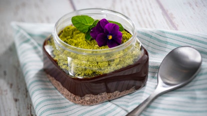A chocolate pudding with a green topping and flowers sits on a table at the 2020 Epcot International...