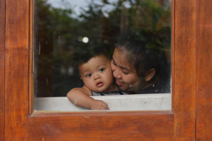 a mother in window with child 