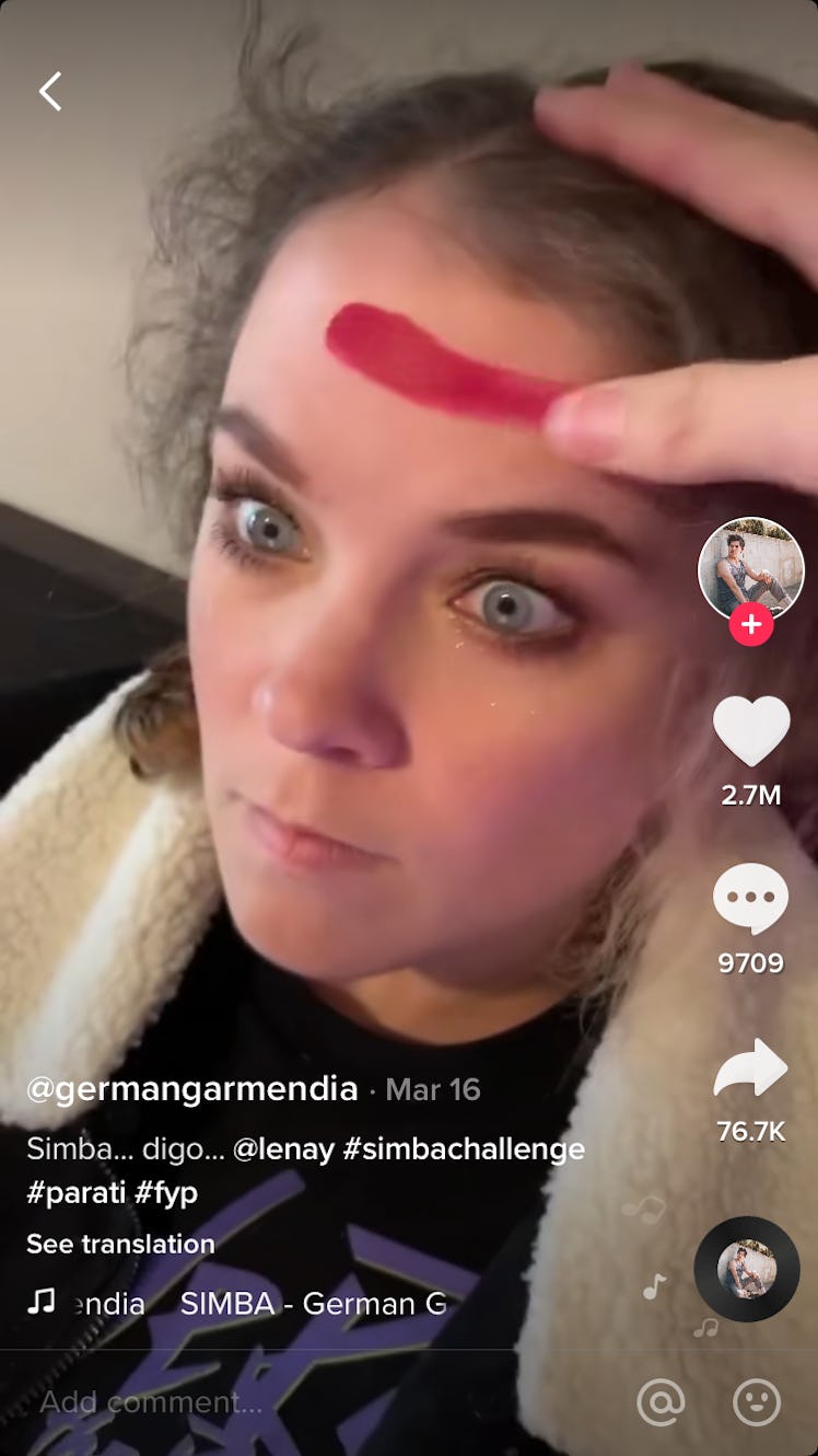 A woman is shocked to have lipstick smeared on her forehead while laying in bed as part of a TikTok ...