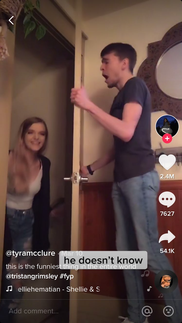 A woman backs out of the doorway as her boyfriend on the other side sings a song. 