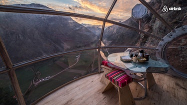 A skylodge in Peru is high above the ground in the mountains, with windows all around.