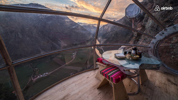 A skylodge in Peru is high above the ground in the mountains, with windows all around so you can see...