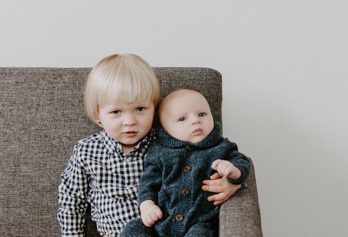 A brother holds his baby sibling