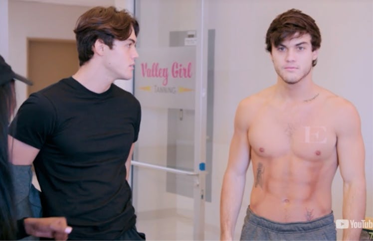 A screenshot from the video of the Dolan Twins getting spray-tan abs with Kevin Hart.