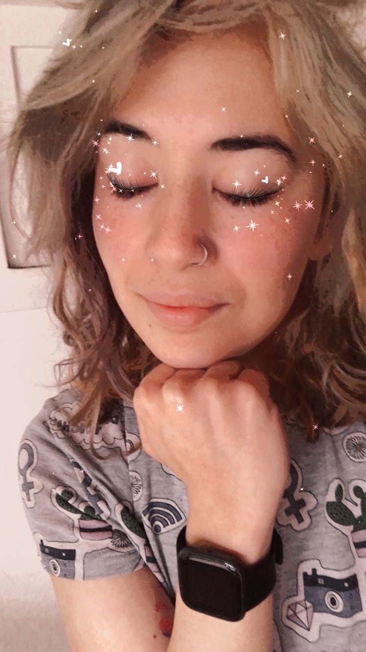 A woman closes her eyes with glitter filtered all around her face. 