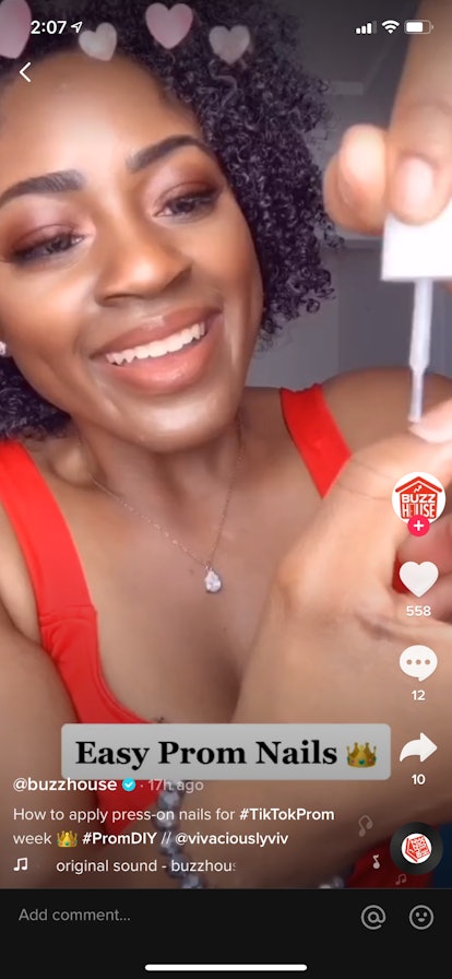 A young woman on TikTok does her own prom nails and applies nail glue.