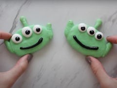 A woman's hands hold onto two Alien-themed macarons from 'Toy Story.'