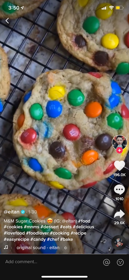 M&M sugar cookies sit on a cooling rack in a TikTok video.