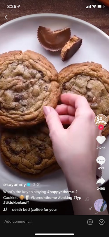 A young woman reaches for a chocolate chip cookie with peanut butter on the inside during a TikTok v...
