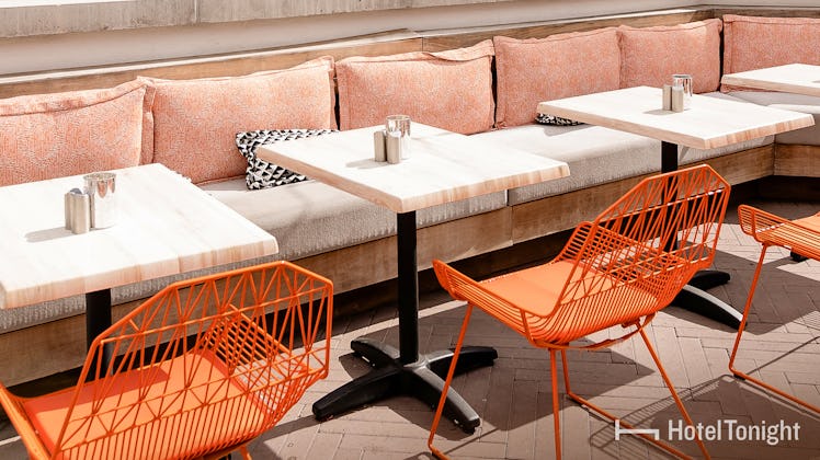 A hotel patio is glowing in the sun, and perfectly designed with orange and pink pieces.