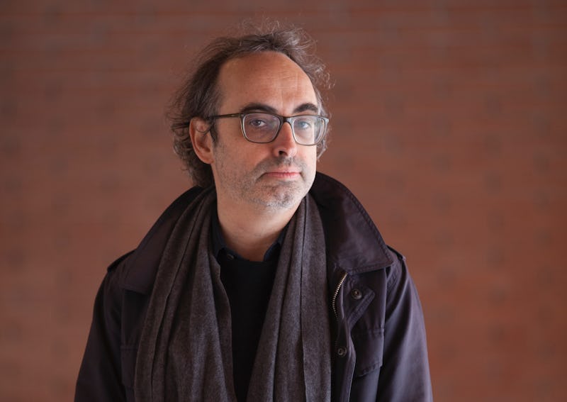 Gary Shteyngart in a black shit, black jacket, and black scarf also wearing glasses