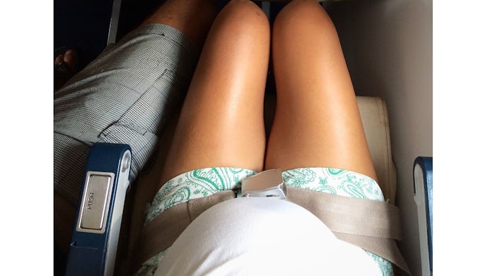 pregnant woman buckled into plane seat