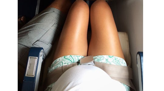 pregnant woman buckled into plane seat