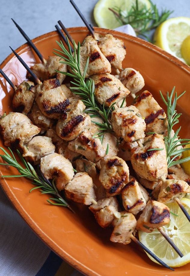 Chicken skewers on a plate with rosemary garnishes