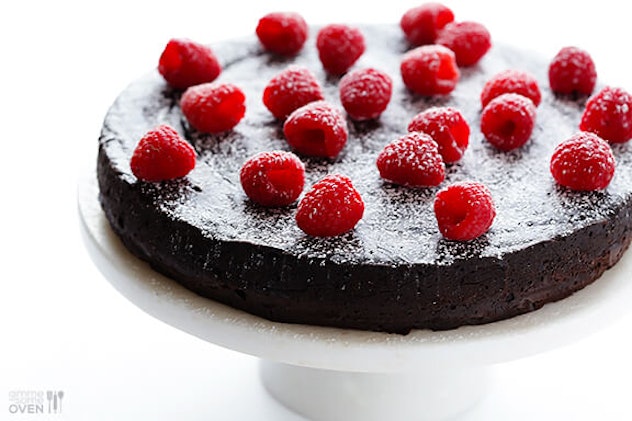 A picture of dark chocolate cake with berries on top.