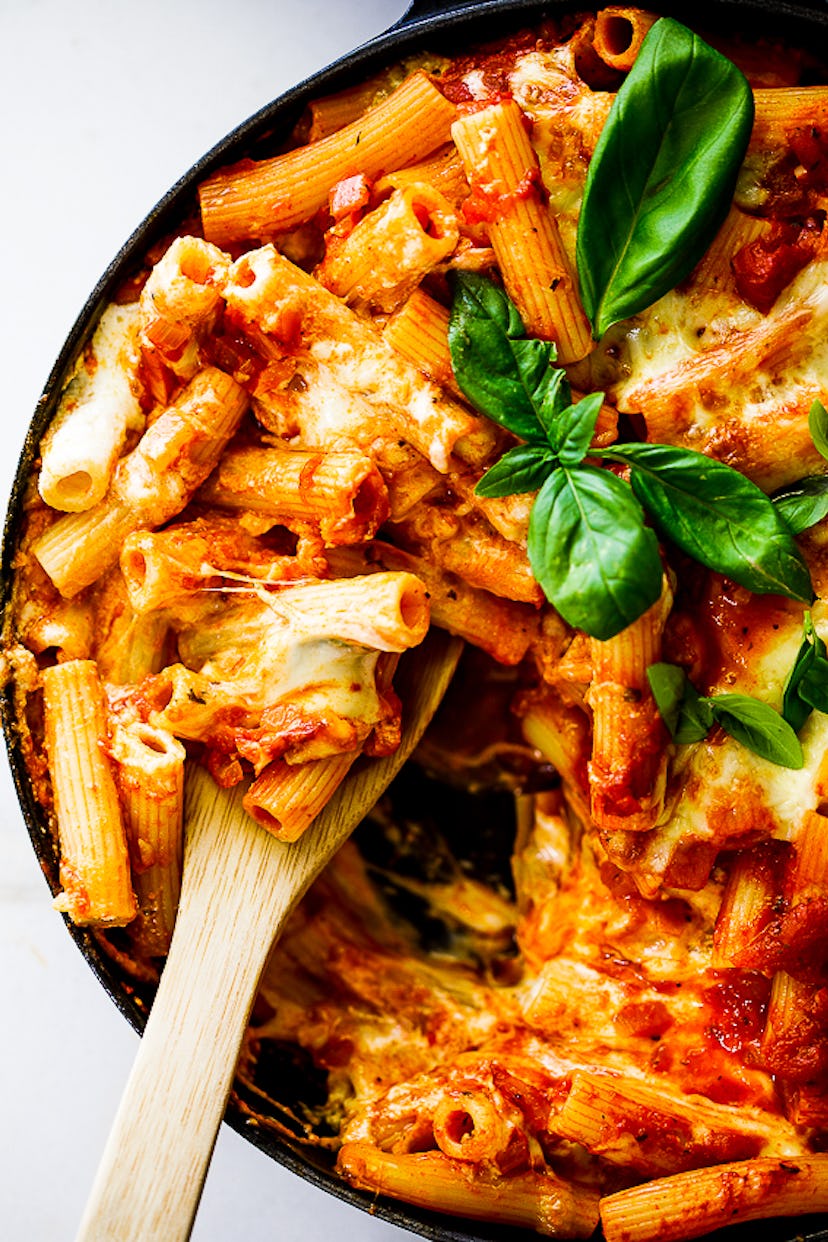 Close up of a dish of baked ziti with garnishes