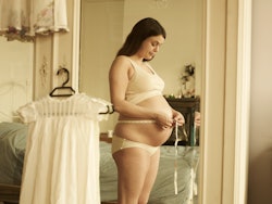 Woman measures pregnant belly