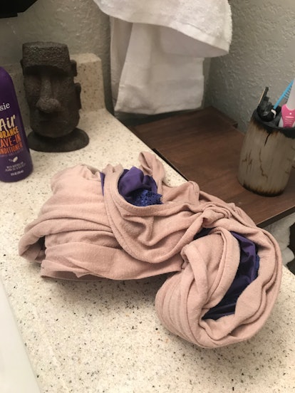 Pile of female clothes on bathroom vanity 