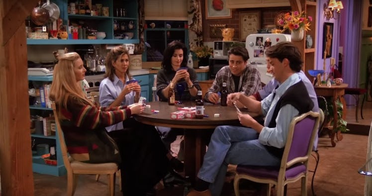 The cast of 'Friends' sit around a table playing poker in Monica's apartment. 