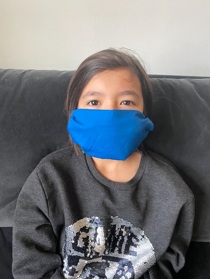 A cute girl in a turquoise face mask.