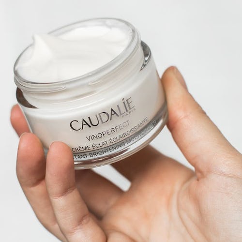 Caudalie's new Vinoperfect Instant Brightening Moisturizer with model.