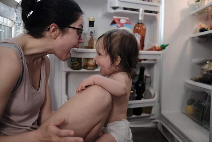 The author, Jen Hyde, and her toddler son share a silly moment in front of their open refrigerator.