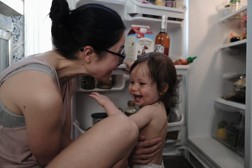 The author, Jen Hyde, and her toddler son share a silly moment in front of their open refrigerator.