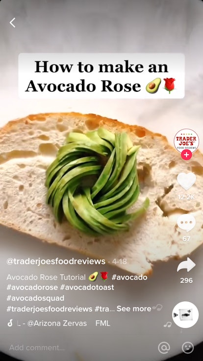 An avocado, shaped like a rose, sits on some toast. 