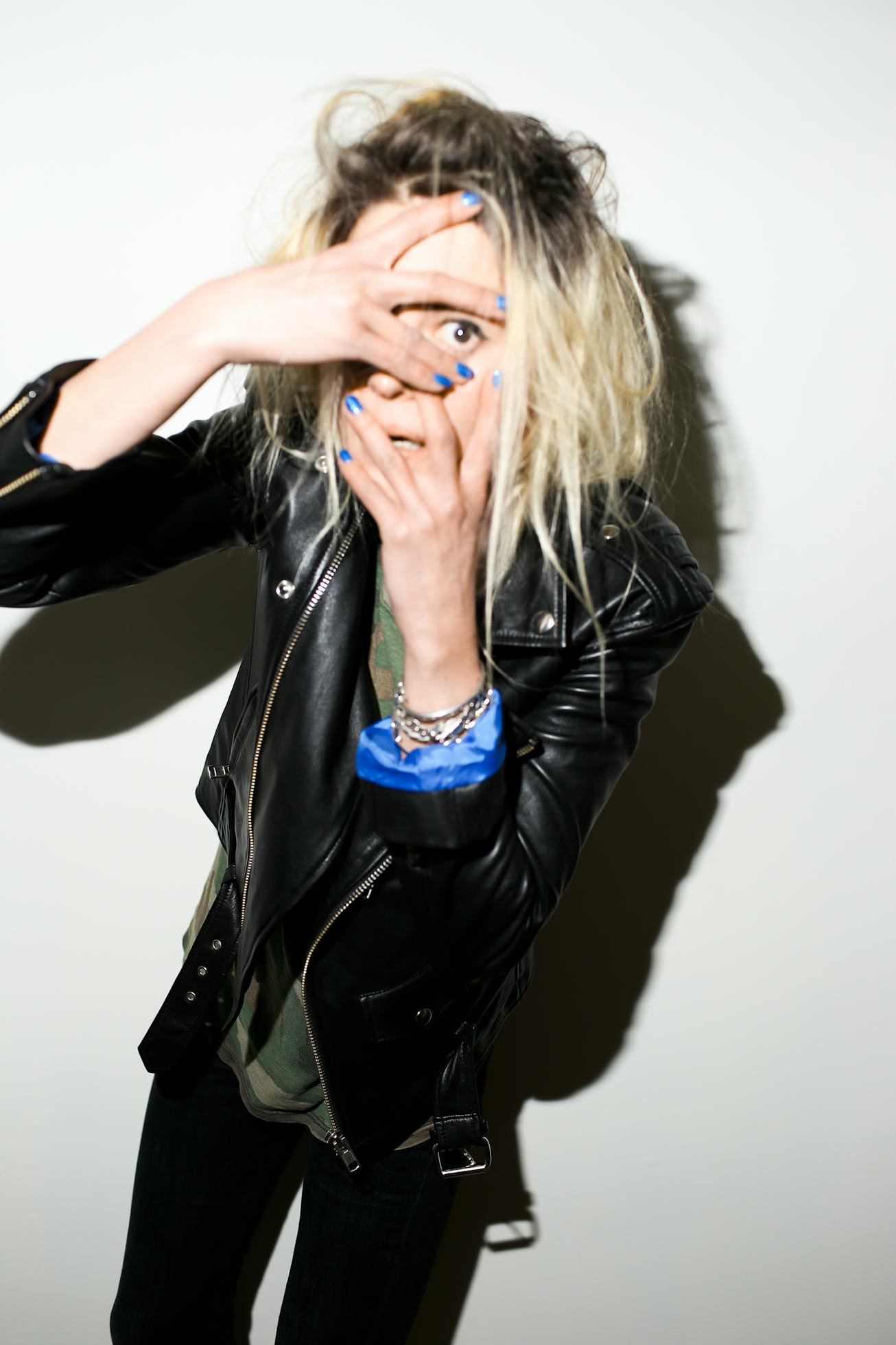 Alison Mosshart peers into the camera, her hand covering everything but her eye.