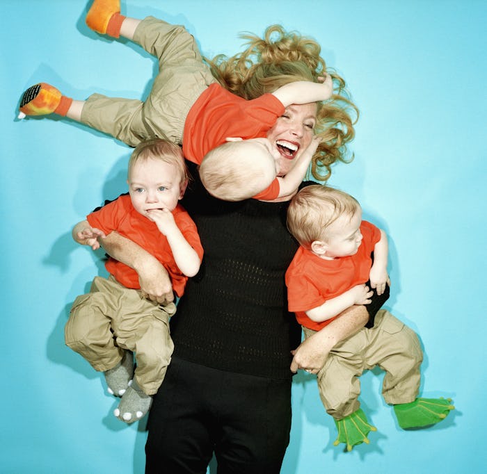 A woman surrounded by babies