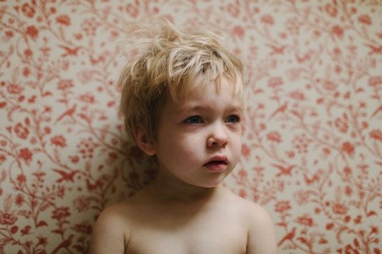 A child standing in front of wallpaper