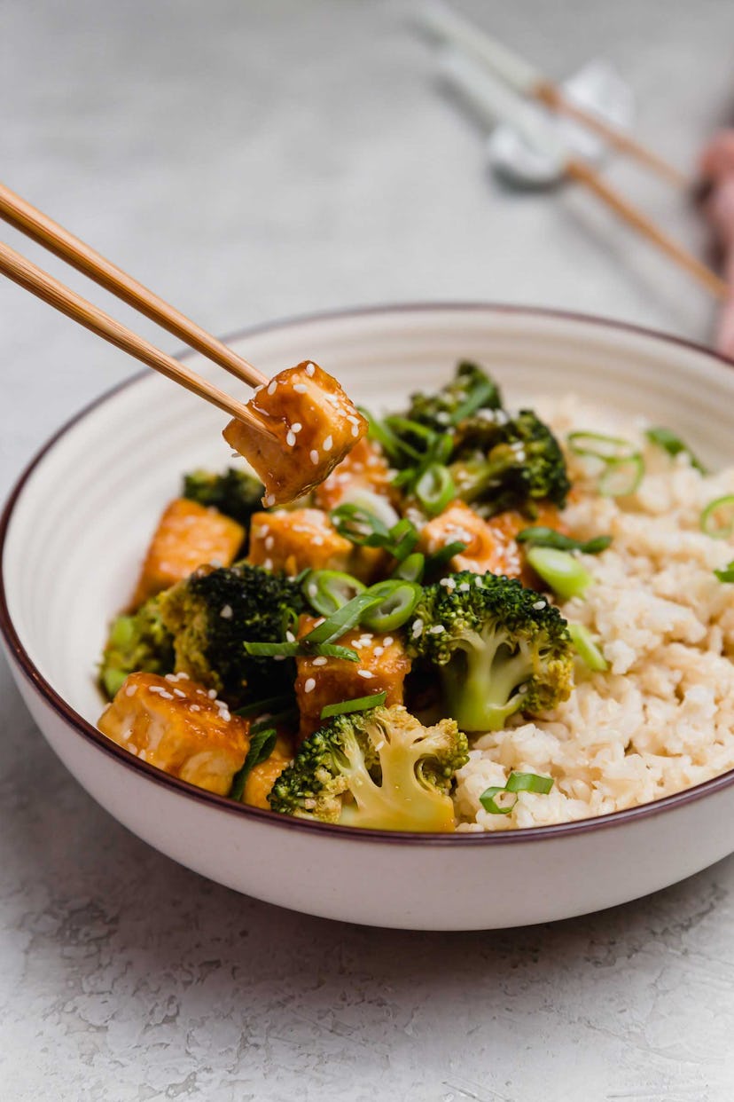 A bowl of savory broccoli and tofu with rich sauce and rice.
