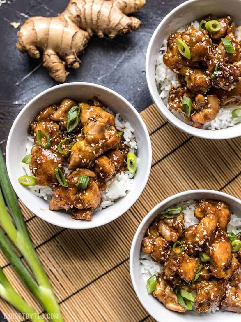 A picture of saucy, sesame chicken over rice. 