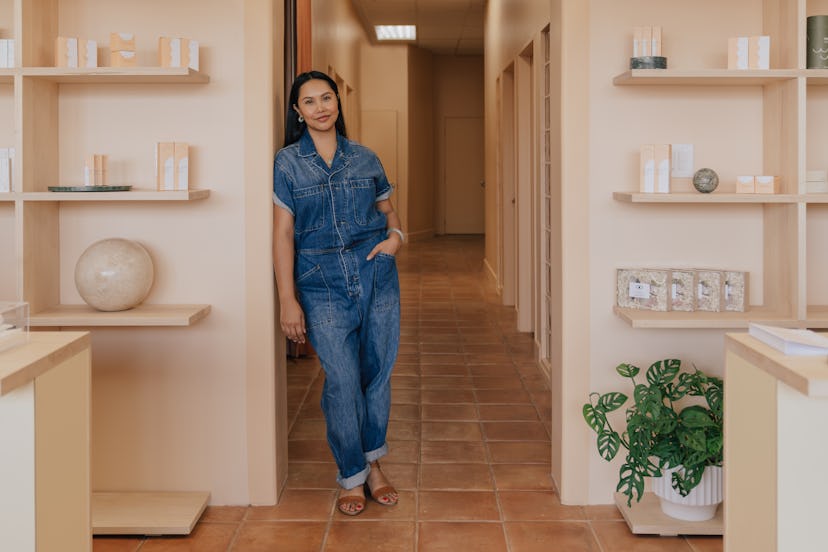 A woman in a blue denim romper in the 'The Things We Do', an L.A. beauty bar with Filipina aesthetic...