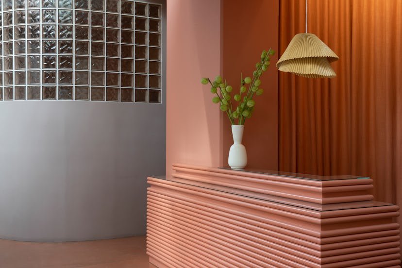 The orange reception corner and a plant at 'The Things We Do', an L.A. beauty bar with Filipina aest...