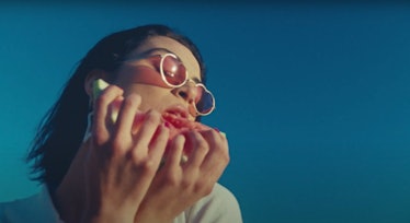 The music video for "Watermelon Sugar" shows a young woman eating a slice of watermelon in sunglasse...