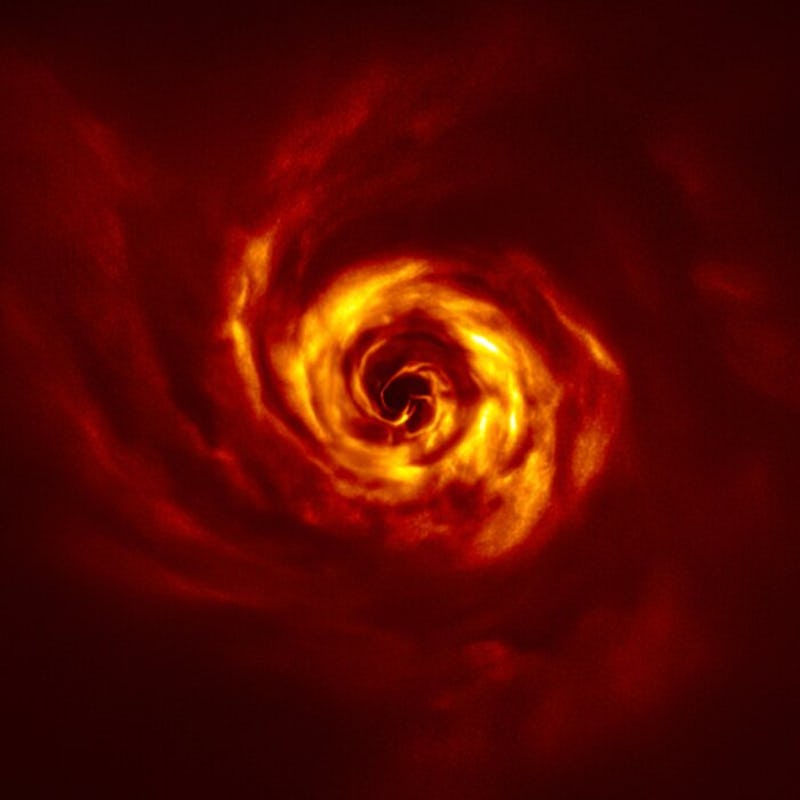 A spiral of gas spinning around the star system AB Aurigae as a new planet is being born