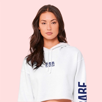 A young woman poses in a white sweatshirt from BABE Wine.