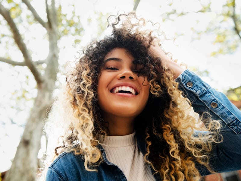 https://www.gettyimages.com/detail/photo/smiling-mixed-race-woman-with-hand-in-hair-royalty-free-ima...