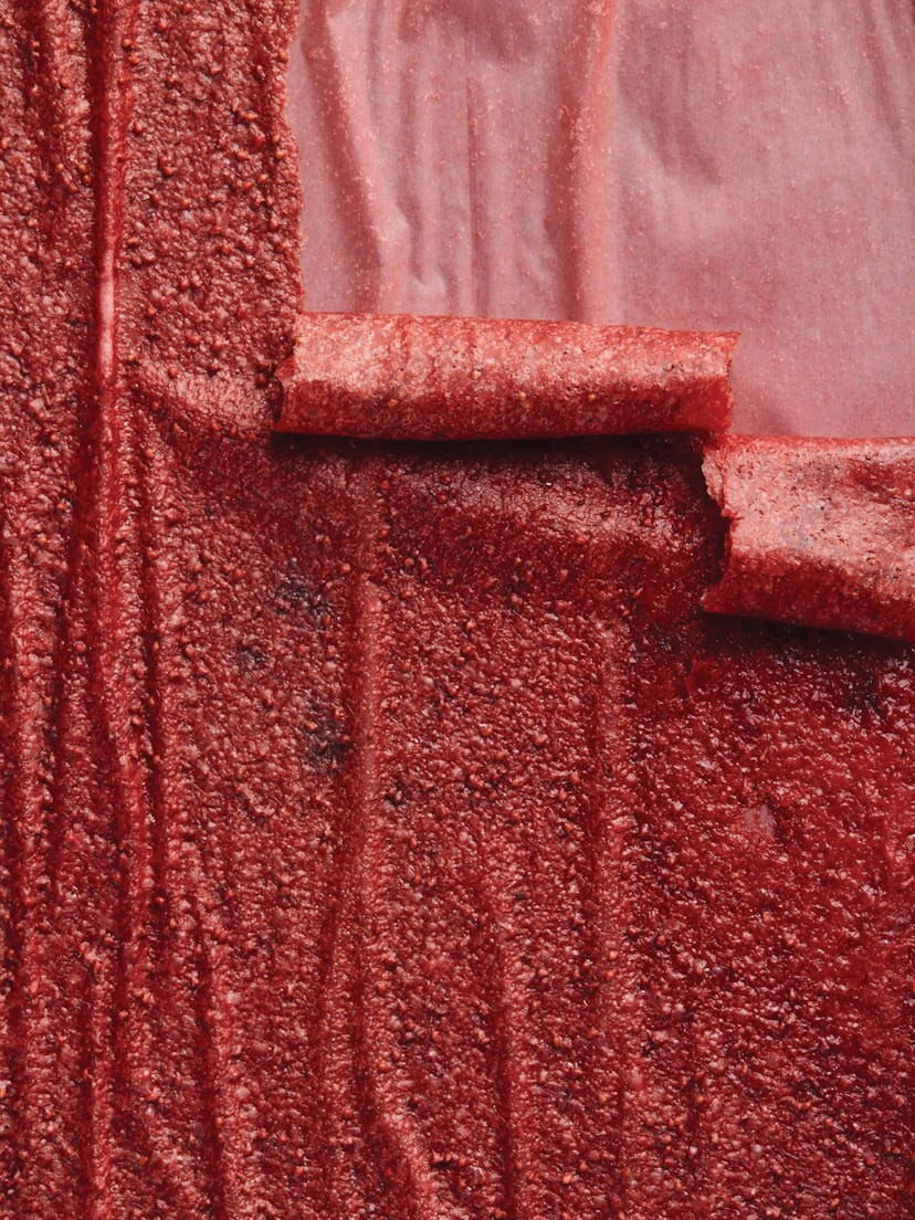 Bright red strips of fruit leather rolling down at different lengths.