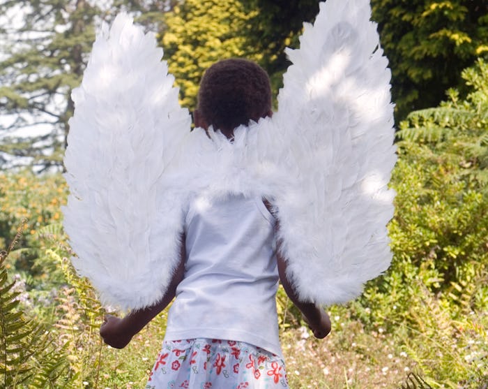 Child walks through woods in wings