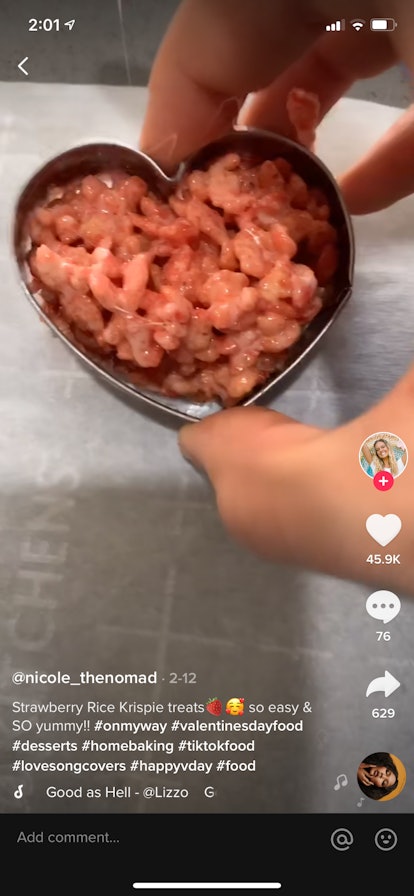Strawberry Rice Krispies Treats are made into hearts on a cookie sheet in a TikTok video.