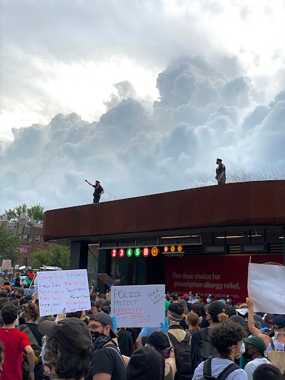 Protesters that have climbed the Barclays Center subway station and stood on its grassy roof beneath...